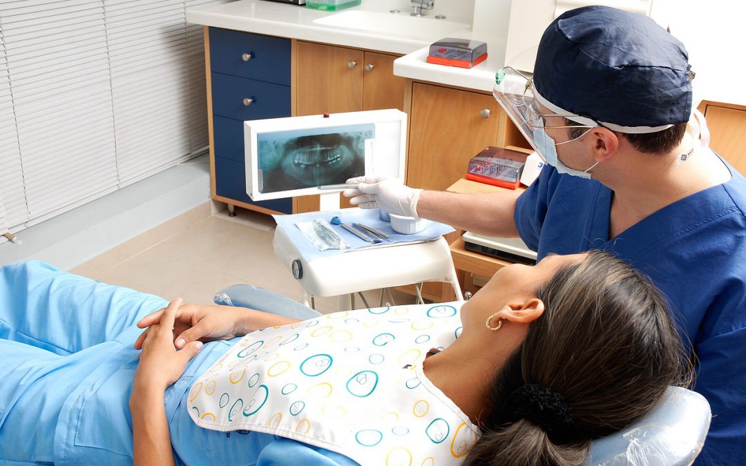 tandarts en patiënt kijken naar foto van gebit